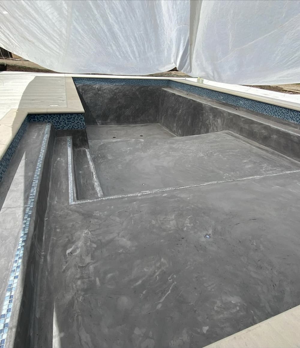 Pool with a new dark finish and mosaic waterline tile
