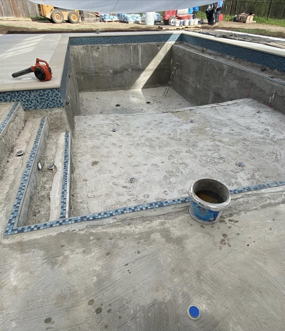 New blue mosaic waterline tile being installed