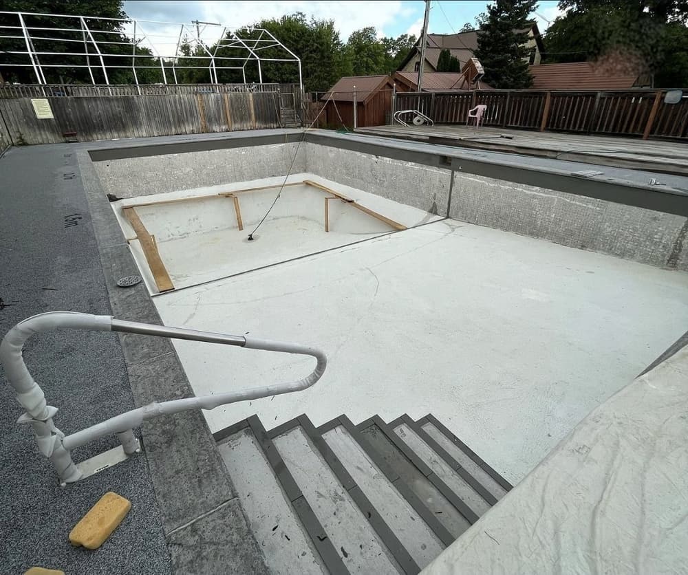 Rectangular concrete pool drained with the old surface prepped for resurfacing